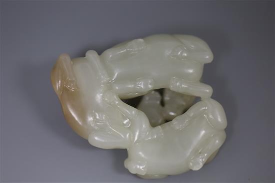 A Chinese pale celadon and russet jade group of three goats, 19th/20th century, 5cm, wood stand